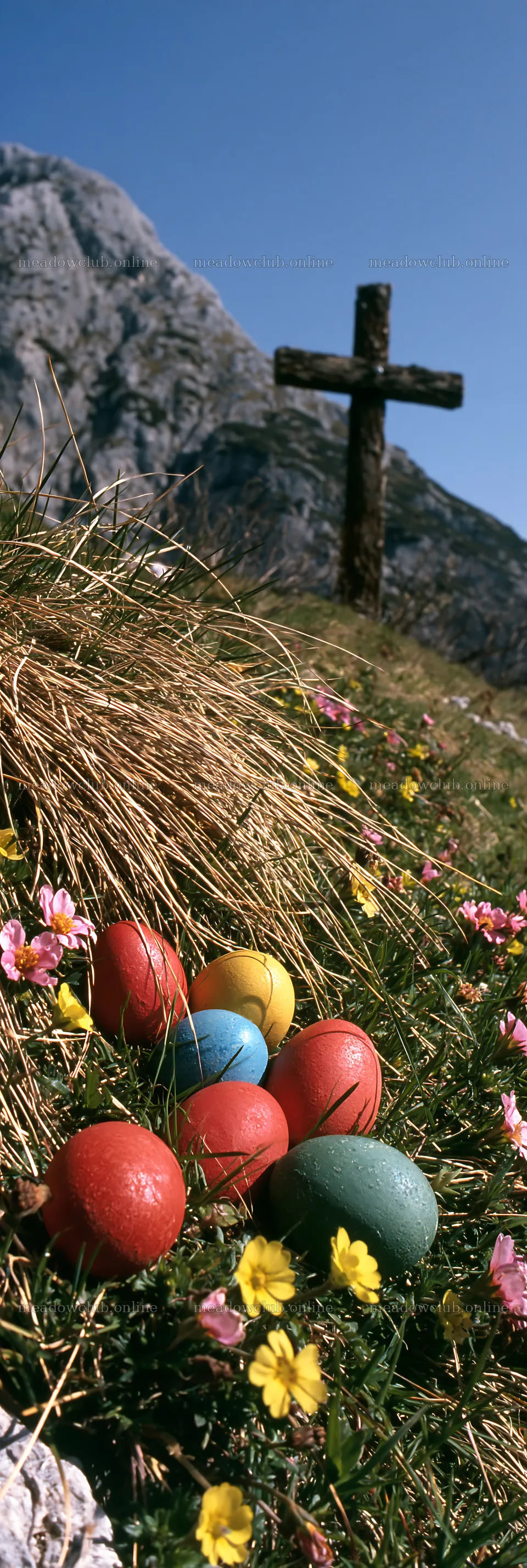 Christian cross above mountain meadow with colored eggs – meadow photos 4602x13690