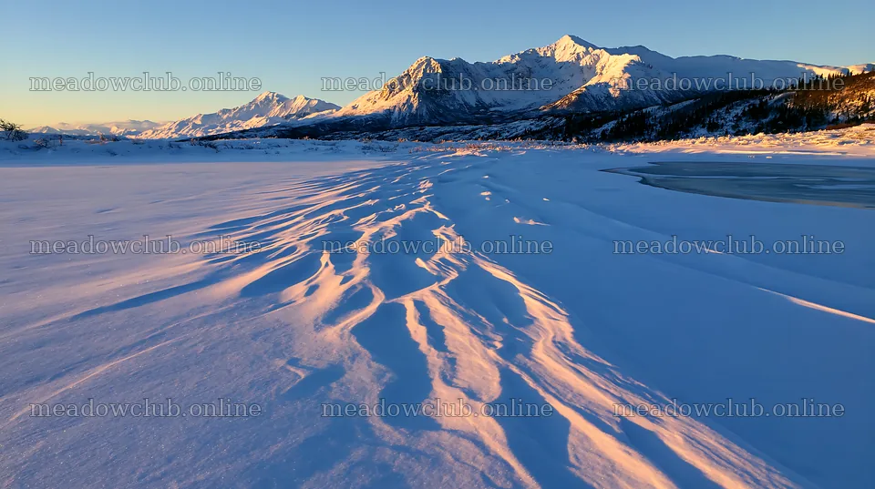 Snowbound meadow under sunlight with mountains in the distance – meadow photos 10608x5938